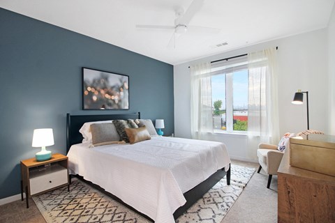 A bedroom with a large bed and a ceiling fan.